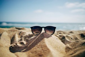 Beach holiday sunglasses in sand