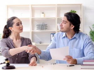 man and woman shaking hands over a contract