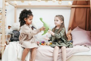 Two girls sharing toy