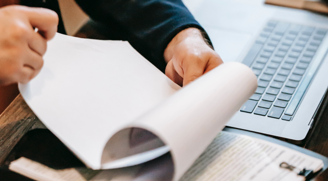A man reviewing documents, flipping through the pages