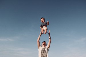 Parenting Plan dad throwing child into the air playing