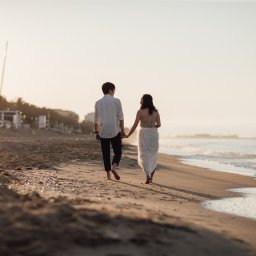 Couple walking on beach holding hands