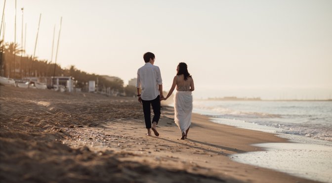 Couple walking on beach holding hands