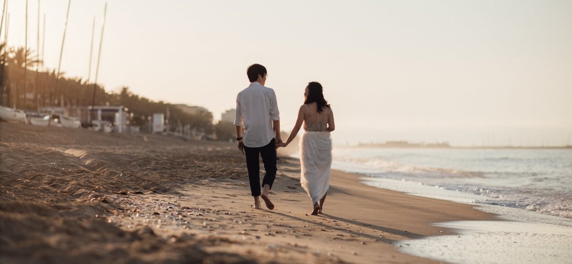 Couple walking on beach holding hands