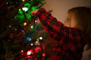 Child putting decorations on the Christmas tree