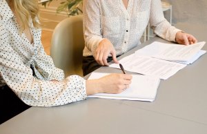 two females discussing paperwork.