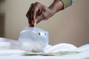 putting coin into clear piggy bank representing what am I entitled to if I divorce my husband?