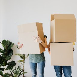 couple moving house holding boxes on divorce