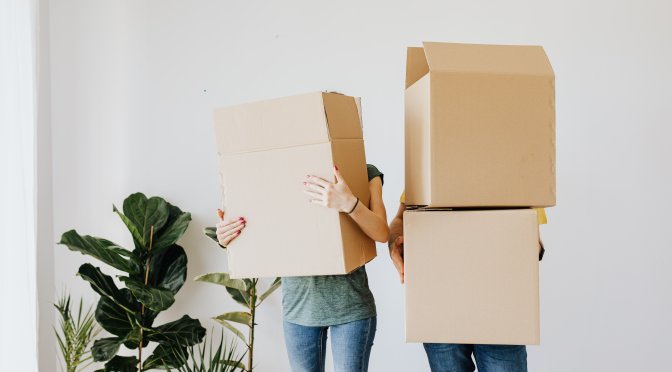couple moving house holding boxes on divorce