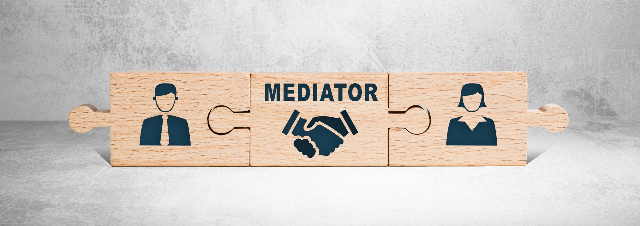 puzzle pieces fitting together with male and female images and mediator in the middle for family mediation week