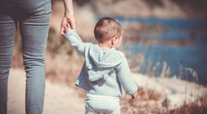 small child holding parents hand