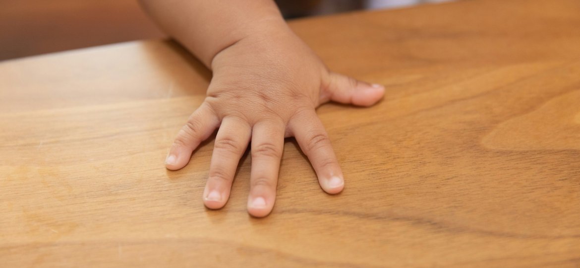 Child Hand resting on a desk