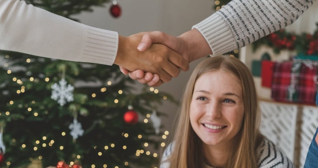 Smiling teenager and separated parents shaking hands in agreement