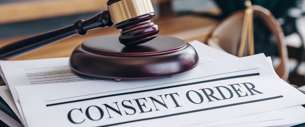 Gavel atop a pile of paperwork labled consent order