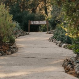 a stone path leading down to a sign that says Mediation
