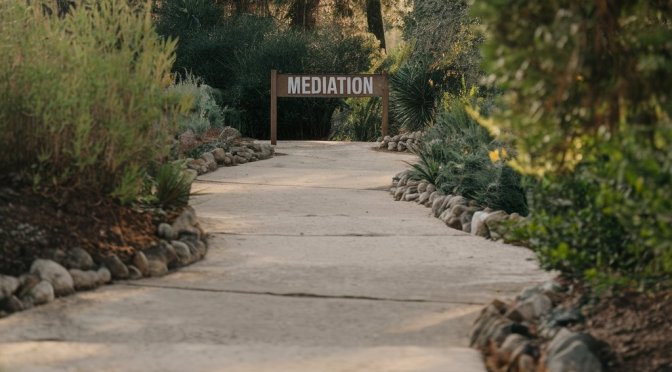 a stone path leading down to a sign that says Mediation