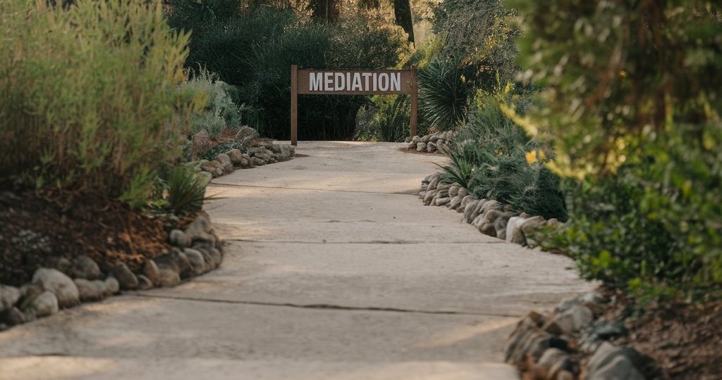 a stone path leading down to a sign that says Mediation