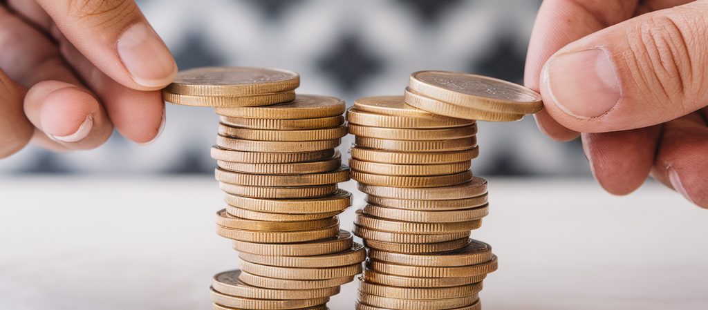 two pile of coins with a male and female hand each taking some away representing financial remedy