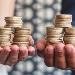 male hand a a female hand piled with coins